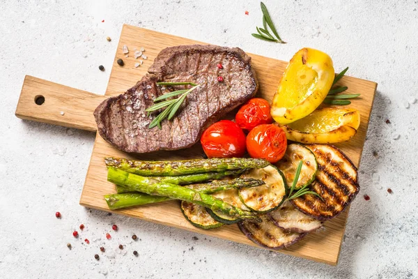 М'ясо на грилі з овочами на білому кам'яному столі . — стокове фото