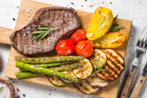 Gegrild vlees met groenten op witte stenen tafel. — Stockfoto
