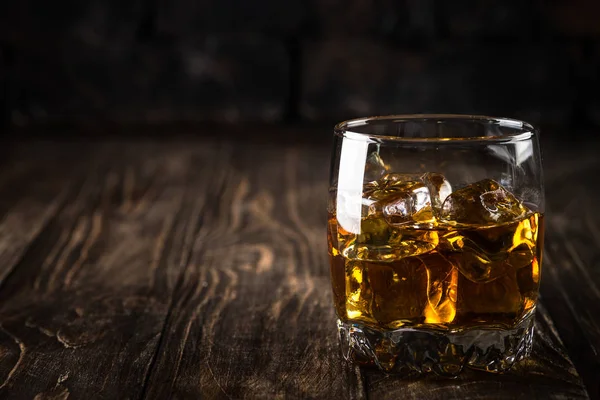 Whiskey in de bril op donkere achtergrond. — Stockfoto