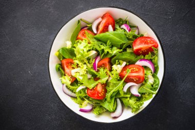 Yapraklar ve domateslerden yeşil salata.