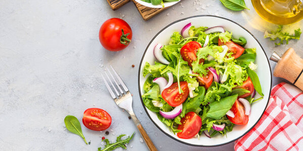 Green salad from fresh leaves and tomatoes.