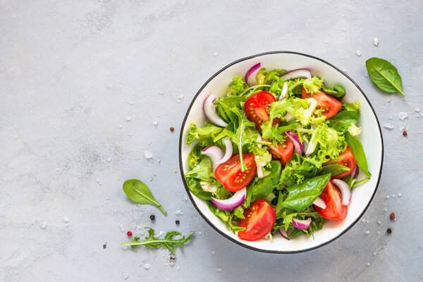 Green salad from fresh leaves and tomatoes.