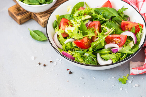 Green salad from fresh leaves and tomatoes.