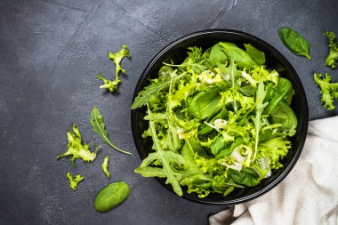 Yeşil salata yaprakları siyah üst görünümde karışır.