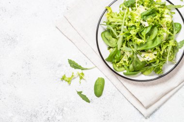Beyaz manzarada yeşil salata yaprakları karışımı.