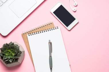 Not defteri, kahve fincanı ve pembe bir arka plan üzerinde klavye ile Ofis İşyeri.