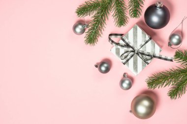 Şimdiki kutu ve dekorasyonlarla birlikte pembe üzerine uzanmış Noel düz arka planı.