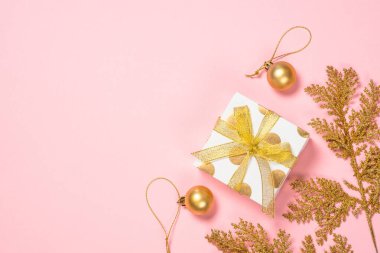 Altın Noel düz zemin pembe üzerine yatıyordu hediye kutusu ve süslemeleri ile.