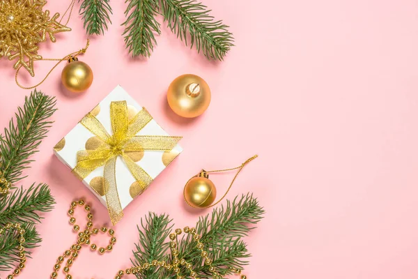 金色的圣诞公寓背景为粉色，配有礼品盒和装饰品. — 图库照片