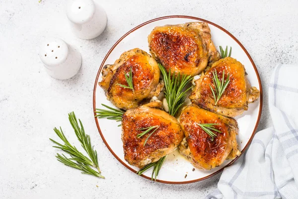 Baked chicken thighs with herbs on white plate. — Stock Photo, Image
