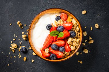 Siyah taş masada taze böğürtlenli Yunan yoğurdu..