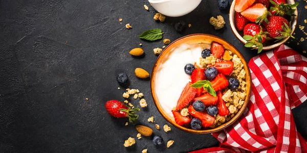 Görög joghurt granola friss bogyókkal a fekete kő asztalon. — Stock Fotó