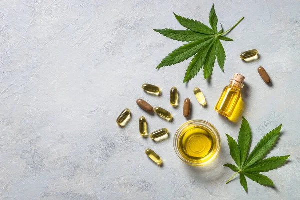 Cannabis oil, pills and green leaves. — Stock Photo, Image