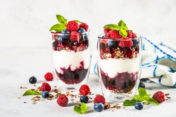 Parfait met granola, jam en verse bessen in de glazen pot. — Stockfoto