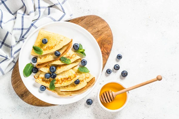 Crepes con arándanos en la mesa blanca. —  Fotos de Stock