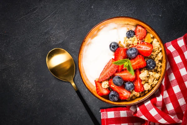 Granola de yogur griego con bayas frescas en la mesa de piedra negra. —  Fotos de Stock