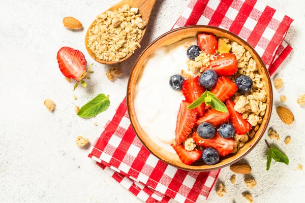 Greek yogurt granola with fresh berries on white stone table. — Stock Photo, Image