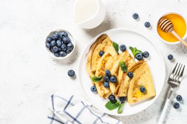 Beyaz masada yaban mersinli krep.