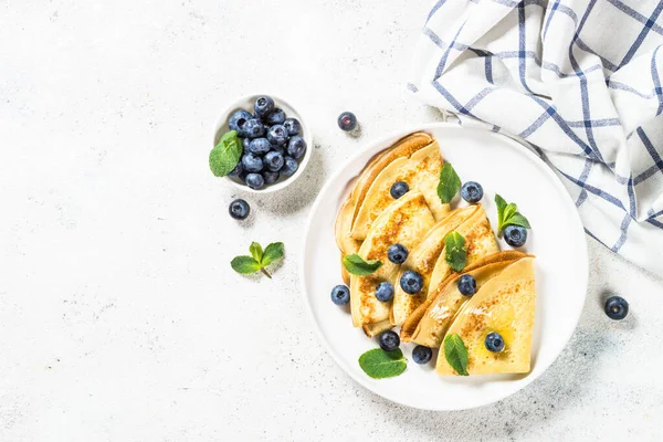 Crepes con arándanos en la mesa blanca. —  Fotos de Stock