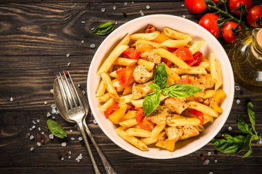 Tahta masada tavuk ve sebzeli makarna..