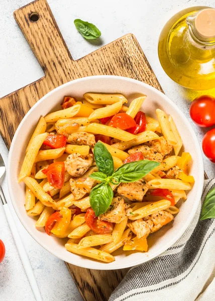 Pasta con pollo y verduras a la mesa blanca. — Foto de Stock