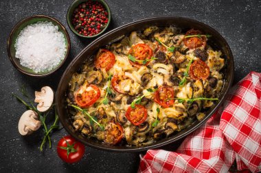 Sebzeli fırında et, siyah masanın üstünde üst görünüm..