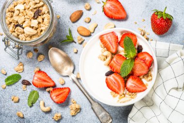Mısır gevrekli yoğurt ve beyaz kasede çilek.