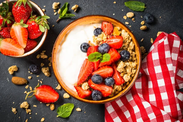 Granola de yogur griego con bayas frescas en la mesa de piedra negra. —  Fotos de Stock