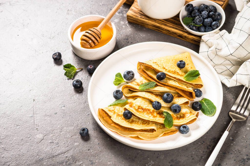 Crepes with blueberries and honey.
