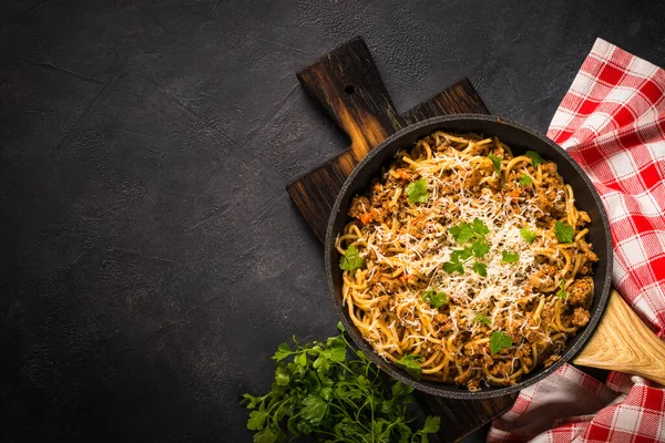 Pasta Bolognese in der Pfanne am schwarzen Tisch. — Stockfoto