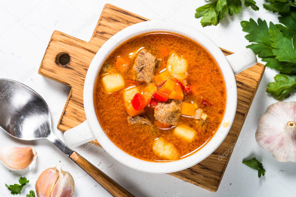 Goulash soup on white stone table top view.