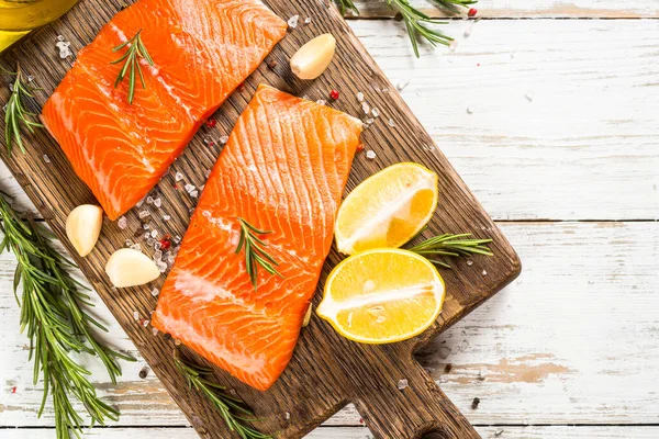 Salmon fish with ingredients at white table. — Stock Photo, Image