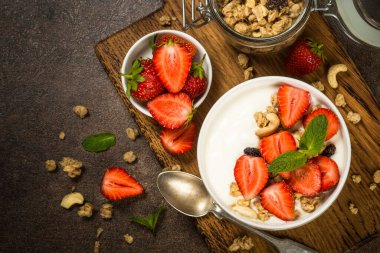 Mısır gevrekli yoğurt ve beyaz kasede çilek.