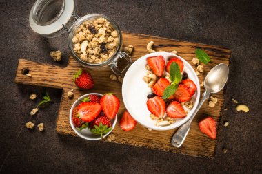 Mısır gevrekli yoğurt ve beyaz kasede çilek.