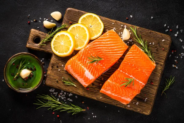 Peixe de salmão com ingredientes à mesa preta. — Fotografia de Stock