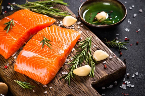 Peixe de salmão com ingredientes à mesa preta. — Fotografia de Stock