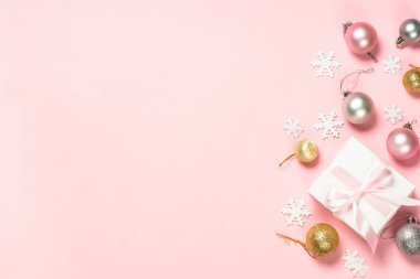 Şimdiki kutu ve dekorasyonlarla Noel pembe düz arka planı.