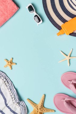 Mavi arka planda deniz kabukları olan yazlık kumaş ve aksesuarlar. Sert gölgeli üst görünüm.