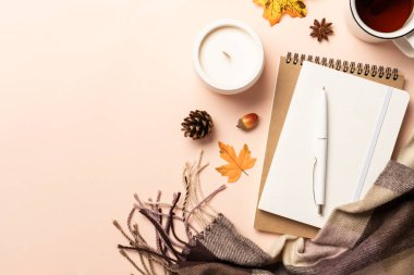 Sonbahar ofis masası. Dizüstü bilgisayar, defter, sarı yapraklı sıcak çay ve fular. Metin için boşluk ile düz uzandı.