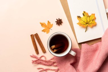 Ofis çalışma alanı. Sarı arka planda sonbahar yaprakları, not defteri, eşarp ve yapraklar.