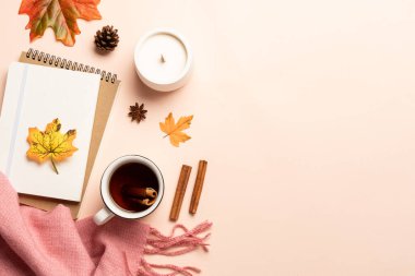 Sonbahar düz arka plan yatıyordu. Sarı arka planda sonbahar yaprakları, not defteri, eşarp ve yapraklar.