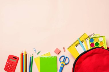 İçinde renkli malzemeler olan okul çantası. Fotokopi alanı olan düz bir yer. Okul konseptine dönelim..