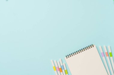 Mavi arka planda not defteri ve kalem. Kopyalama alanı olan düz.