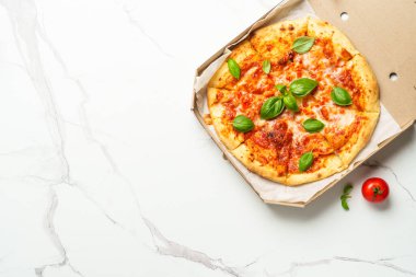 Beyaz arka planda karton bir kutuda pizza Margarita. Lezzetli öğle veya akşam yemeği, fast food.