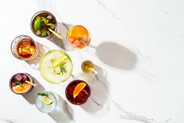 Kokteyl partisi, alkol kokteyli. Beyaz arka planda viski, margarita, Aperol spritz, Küba libre, negroni, sangria ve jin toniği. Kopyalama alanı olan üst görünüm.