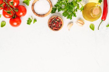 Baharatlar, otlar ve sebzeler ve beyaz mutfak masasında zeytin yağı. Kopyalama alanı olan üst görünüm.