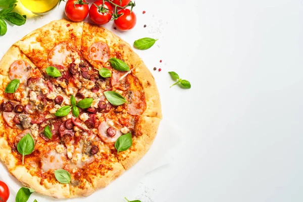 Beyaz arka planda pizza ve yemek malzemeleri. Jambonlu, salamlı ve sosisli lezzetli et pizzası. Üstteki görünüm beyaz ve metin için boşluk.