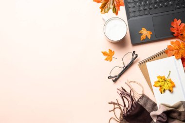 Sonbahar ofis masası. Dizüstü bilgisayar, defter, bir fincan kahve ve sıcak eşarp. Metin için alanı olan en üstteki görüntü.