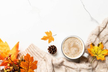 Sonbahar düz arka plan yatıyordu. Kahve, rahat süveter ve sarı yapraklar..