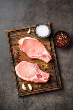 Kesme tahtasında çiğ domuz eti bifteği. Kopyalama alanı olan düz.